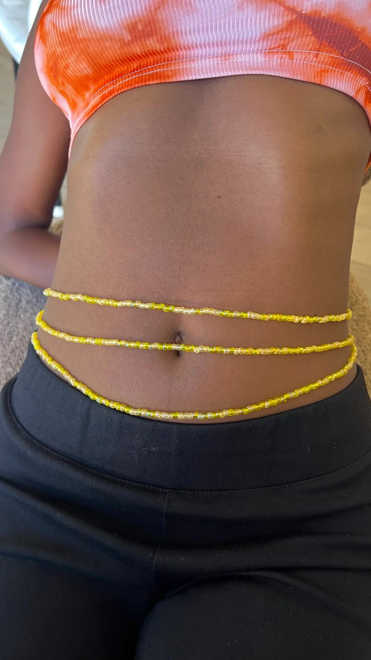 Trois chaînes de taille beaded baya douceur jaunes avec accents blancs subtils alignées parallèlement