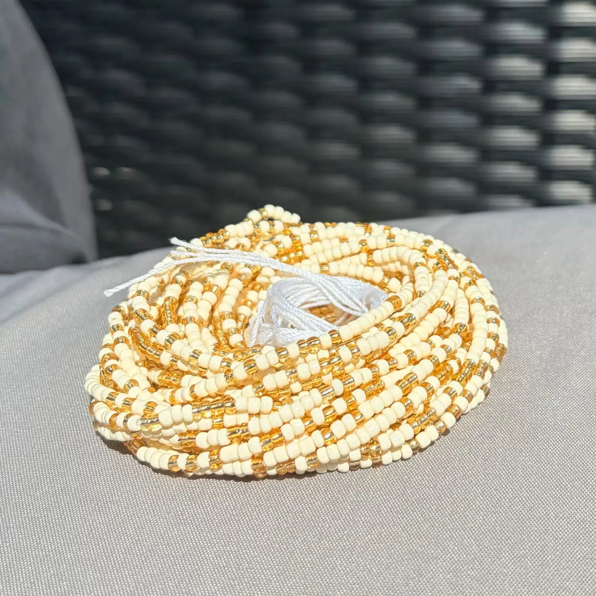 Collier baya sunshine en perles enroulées avec perles crème et dorées alternées attaché par un lien blanc